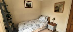 a small bedroom with a bed and a mirror at Dumble Cottage in Minehead +8 photos