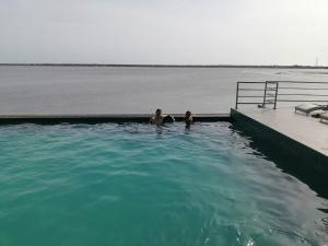 two people in a swimming pool in the water at Oruwa Boutique Villas in Arugam Bay