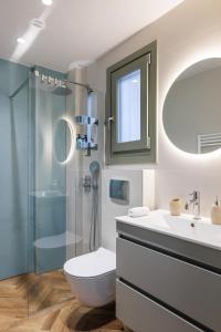 a bathroom with a shower and a toilet and a sink at Helia All Seasons Apartments in Astris
