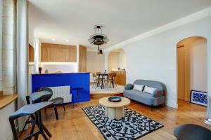 uma sala de estar com um sofá e uma mesa em Villa Les Hirondelles - Appartement avec Jardin Front de mer em Saint-Aubin-sur-Mer