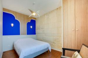 um quarto com uma cama e uma parede azul em Villa Les Hirondelles - Appartement avec Jardin Front de mer em Saint-Aubin-sur-Mer