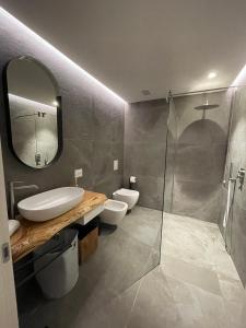 bagno con lavandino, servizi igienici e specchio di Villa Elvira a Gardone Riviera