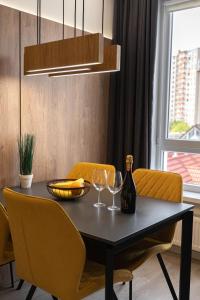 a dining room table with two glasses and a bottle of wine at RentWill apartments Yellow in Chişinău