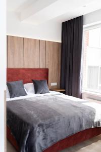 a bedroom with a large bed with a wooden headboard at RentWill apartments Yellow in Chişinău