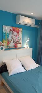 アグドにあるBedroom Agde 34300の青い壁のベッドルーム1室、ベッド1台(枕2つ付)