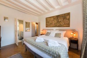 a bedroom with a large bed with towels on it at L'Orée du Mans in Sillé-le-Philippe +47 photos