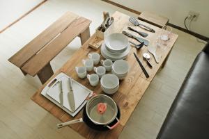 una mesa con platos y tazas y una olla en ella en 南箱根ツリーハウス, en Kannami