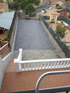 Elle offre une vue aérienne sur une terrasse dotée d'une clôture blanche. dans l'établissement CASA LA SABONERA, à Vilajuiga