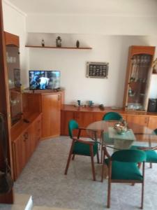sala de estar con mesa, sillas y TV en CASA LA SABONERA en Vilajuiga