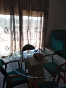 a glass table and chairs in a room with a window at CASA LA SABONERA in Vilajuiga