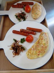two plates of food with sausage and vegetables on a table at Oruwa Boutique Villas in Arugam Bay