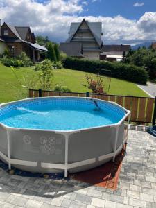 a large hot tub sitting on a patio with a yard at Chatka u Staszka in Małe Ciche
