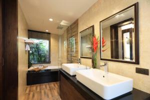 a bathroom with a tub, sink, and mirror at Celes Beachfront Resort Koh Samui - SHA Extra Plus in Bophut