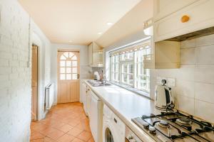 a kitchen with white counters and a stove top oven at Darwen in Rugeley