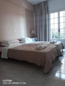 a bedroom with a large bed with towels on it at DVLNG FAMILY STUDIO APARTMENT in Kassiopi