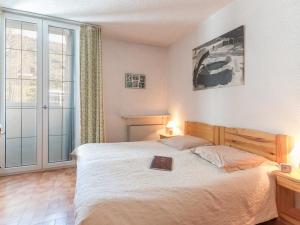 Un dormitorio con una cama con un libro. en Appartement Saint-Chaffrey , 3 pièces, 10 personnes - FR-1-330E-15 en Saint-Chaffrey