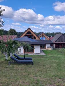 um grupo de espreguiçadeiras com um guarda-sol num quintal em Ca' Fam Chalets em Lazisko