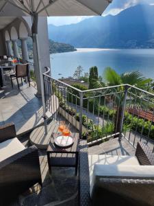 a balcony with a view of the water at Wohlfühl-Oase mit Traumblick für alle Generationen inkl Aufzug in Gambarogno