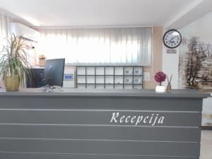 an office with a reception desk with a clock at Konak kod Hame in Bihać