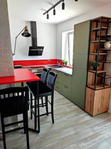 a kitchen with a red counter and a red table and chairs at Apartments Vidanovic in Ohrid