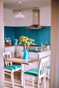 a kitchen with a table with a vase of flowers on it at Bamboo House in Corralejo