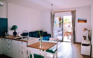 a kitchen and living room with a table and a dining room at Bamboo House in Corralejo