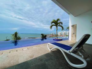 een stoel op een patio naast een zwembad bij Paraíso frente al Mar Caribe en Cartagena. in Cartagena