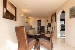 uma sala de jantar com uma mesa de vidro e cadeiras em Seabreeze Carihuela Apartment em Torremolinos