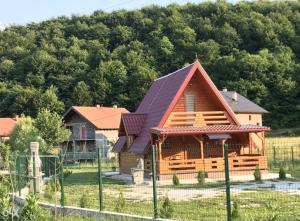 una cabaña de madera en un campo con una valla en Vikendica Bosnjak, en Sarajevo