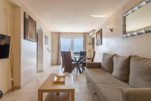 uma sala de estar com um sofá e uma mesa em Seabreeze Carihuela Apartment em Torremolinos