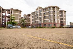 a parking lot in front of a large building at Bonaventure Apartment A in Kisumu