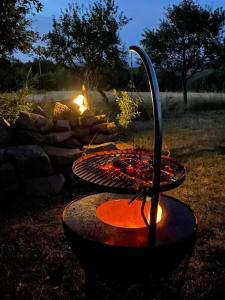 a grill in front of a fire in a yard at Romantic Wildlife Tipi Teepee Tomnatic Bihor Romania Apuseni in Tomnatic