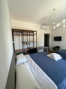 um quarto com uma cama grande e um cobertor azul em Policaretto Rooms em Torretta