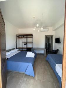um quarto com 2 camas e lençóis azuis em Policaretto Rooms em Torretta