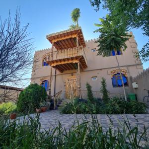 una casa con balcón en la parte delantera en Shahriston - Hotel Khiva, en Khiva