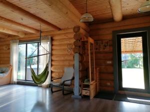 una habitación con una hamaca en una cabaña de madera en Palmas, en Jūrkalne
