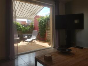 uma sala de estar com uma porta de vidro deslizante para um pátio em Joli appartement 50 m2 classé 3 etoiles avec terrasse et jardin em La Rochelle