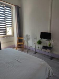 1 dormitorio con 1 cama, TV y ventana en Gîte Chanay 80 m2 Tournus 2 chambres en Tournus