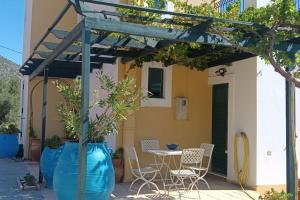 a patio with a table and chairs under a pergola at Το σπίτι που σε ταξιδεύει (The dream boat house). in Agia Galini +43 photos