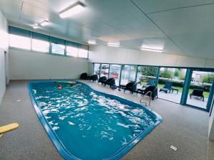 una gran piscina en una habitación con sillas en Captains Cove 1st Floor Spa Luxury Apartments - Free Netflix, en Paynesville