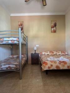 a bedroom with two bunk beds and a night stand at Casa Rural El Cuco in Luque