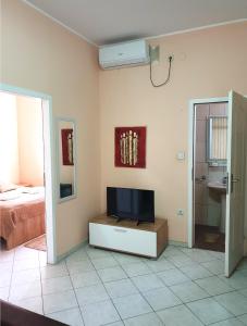 ein Wohnzimmer mit einem TV und einem Bett in der Unterkunft ATRIJUM apartmani Apatin in Apatin