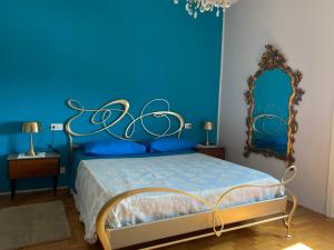 Dormitorio azul con cama y espejo en Giulia's Apartment in Milan Bicocca, en Milán