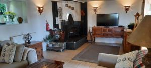 a living room with a couch and a flat screen tv at Trelake Cottage in Tintagel