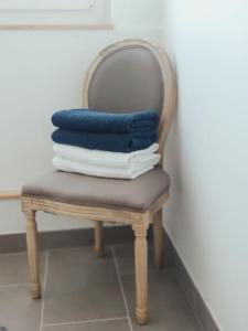 een stapel handdoeken zittend op een stoel bij Les Coquelicots in Honfleur
