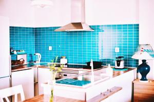 a kitchen with blue tiles on the wall at Bamboo House in Corralejo
