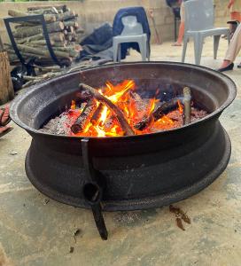 a grill with fire in it on a table at Riverside Cottage Winterton in Winterton