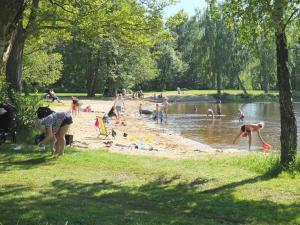 a group of people playing on the beach in a park at Tydingesjöns Camping & Festplats in Broby +3 photos