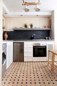 a kitchen with a black and white tile floor at Dar Tahendit in Tangier