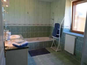 a bathroom with a bath tub and a sink and a bath tub at Pontmain (53) Chambre privée proche de Fougères in Pontmain